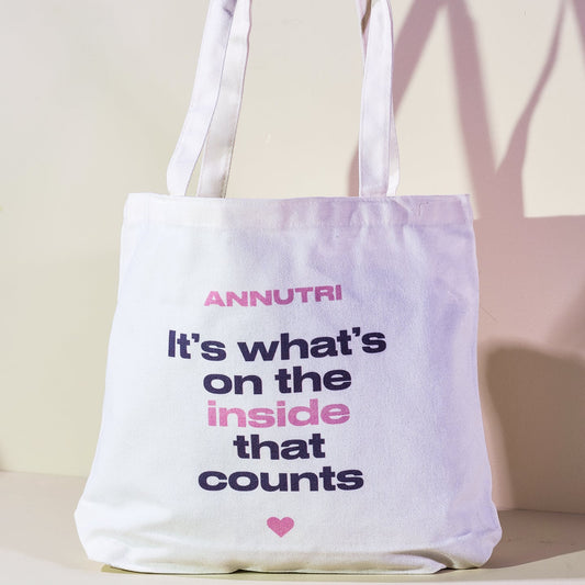 White tote bag with text and ANNUTRI branding on a light background