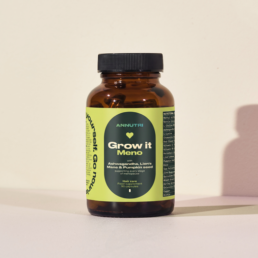 Brown supplement bottle with green label on a beige background
