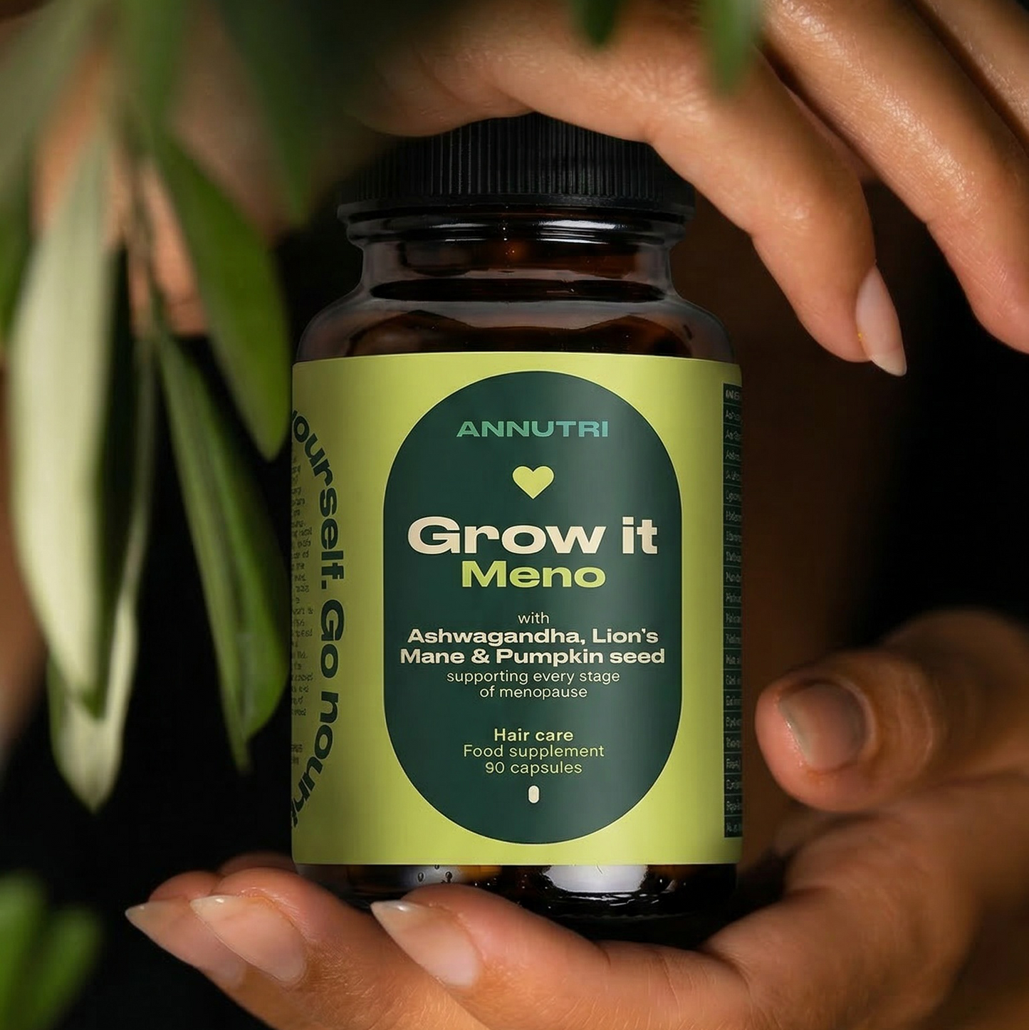 Hand holding a bottle labeled 'Grow it Mano' with a green label against a dark background.