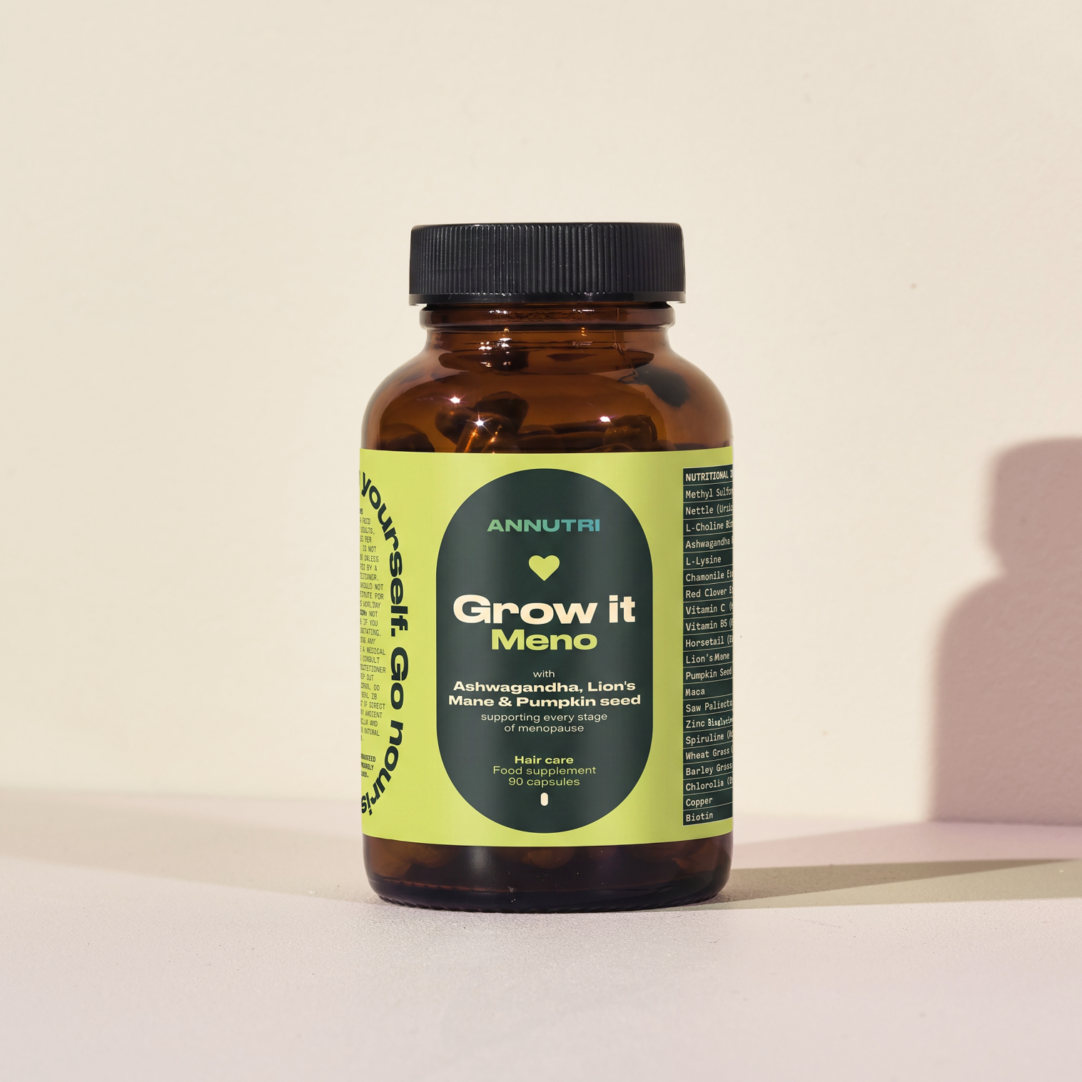 Brown supplement bottle with green label on a beige background